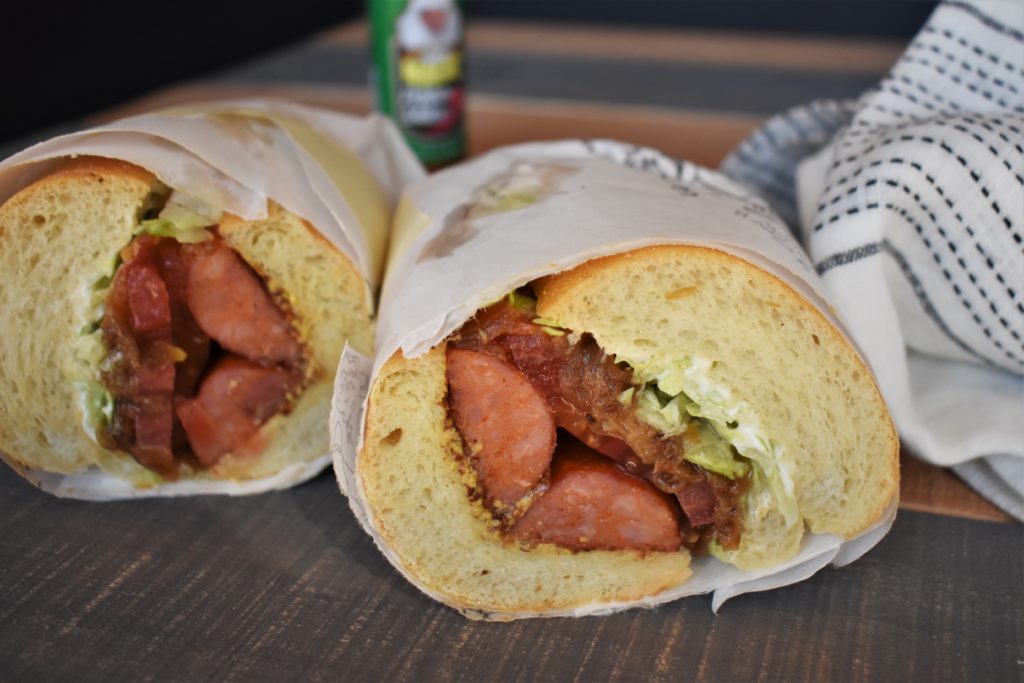 an andouille smoked sausage po boys cut in half on a table