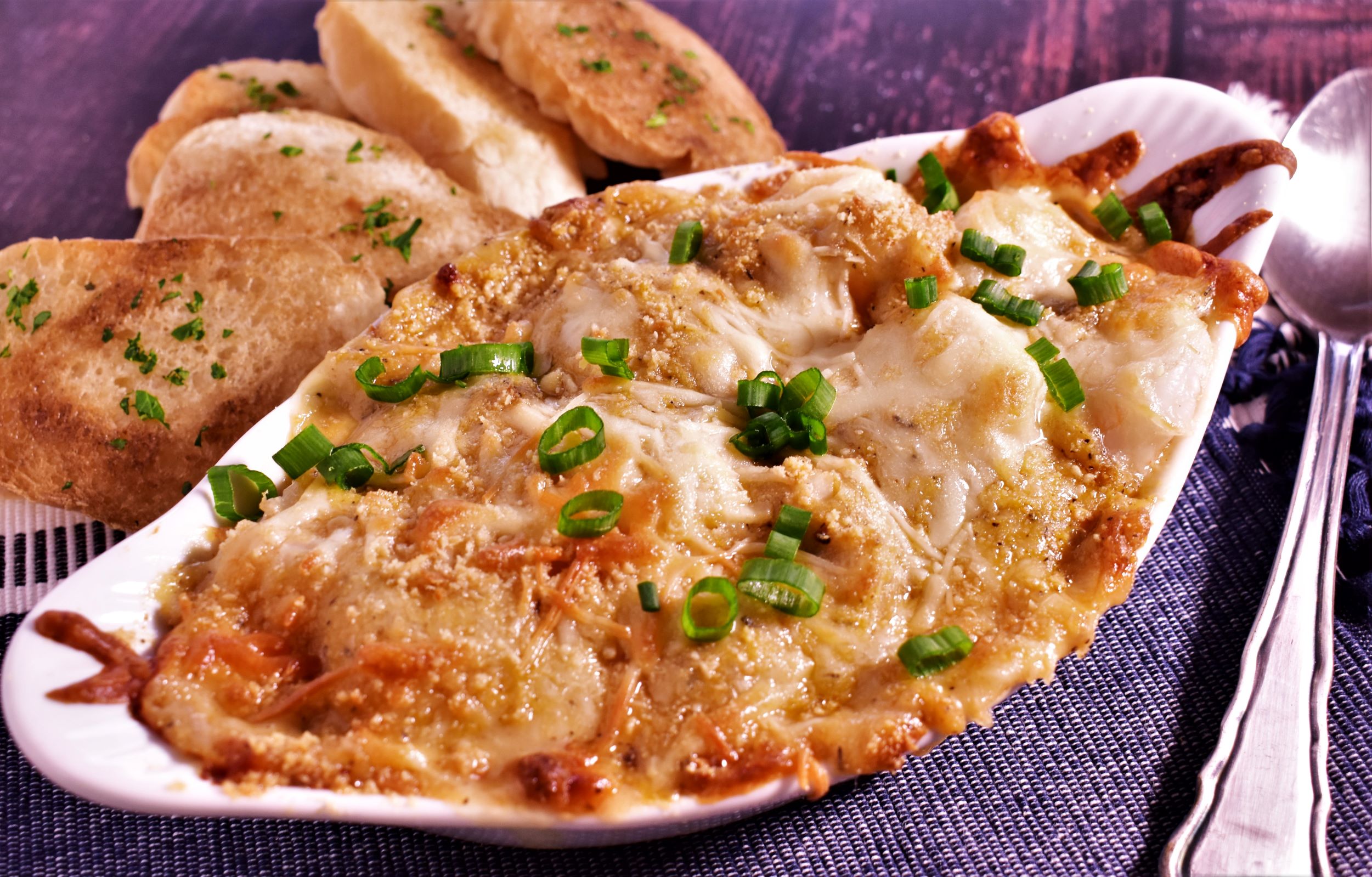 a plate of avery island seafood gratinee and a few pieces of bread on the side