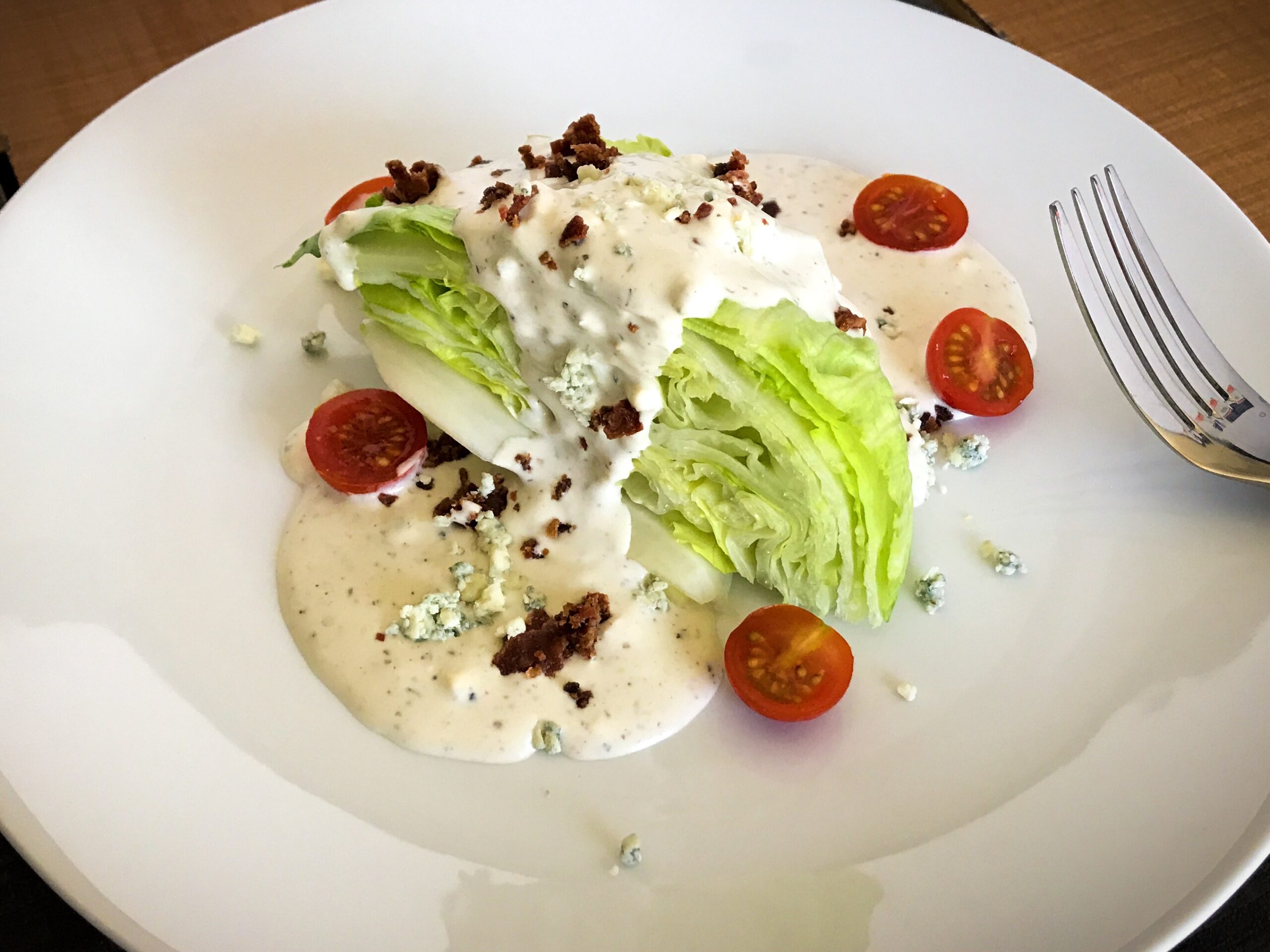 a plate of creamy blue cheese salad dressing on a salad