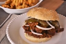 a plate with a barbeque brisket dressed with white onions and pickles