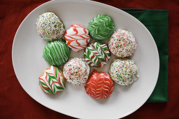 10 christmas cookies decorated differently on a plate