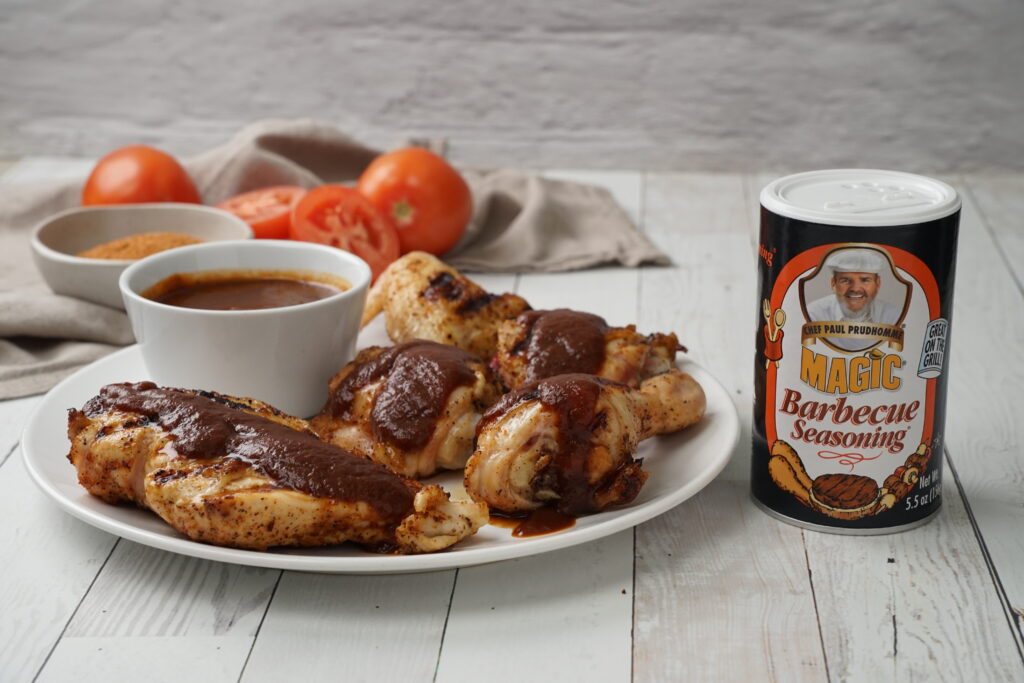 barbecue chicken on a plate next to magic seasoning shaker