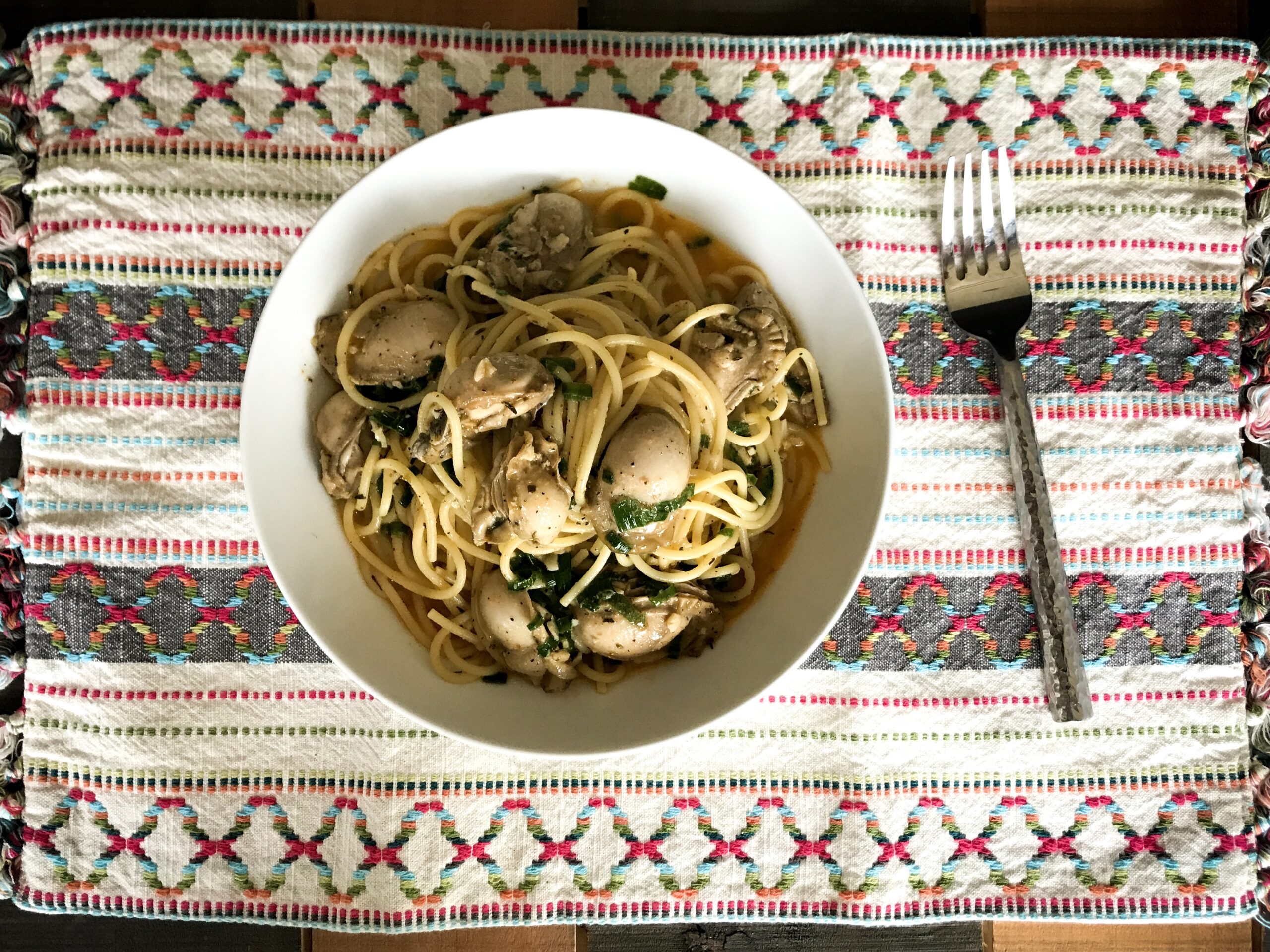 a bowl of garlic oyster seafood on pasta