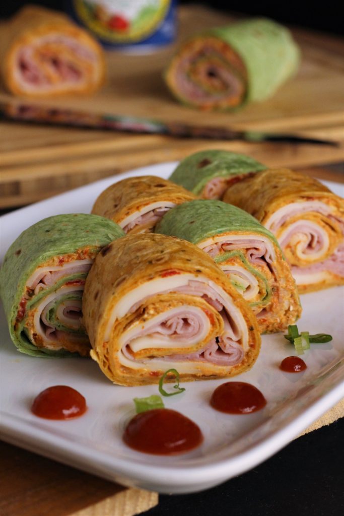 a plate of 6 cream cheese and ham tortilla rolls