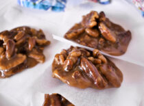 Three pecan pralines resting on parchment paper.