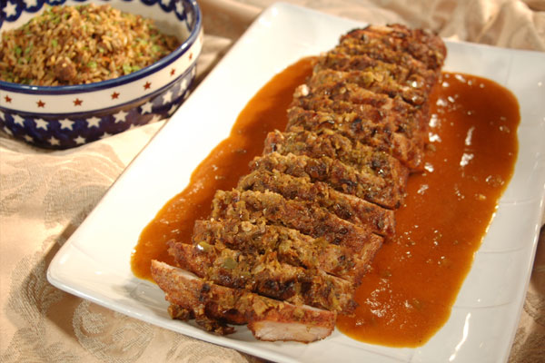 a plate full of roasted pork cut into 15 slices of pork, sitting in a bunch of gravy