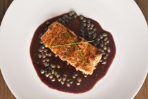 a plate with bronzed salmon with merlot caper sauce