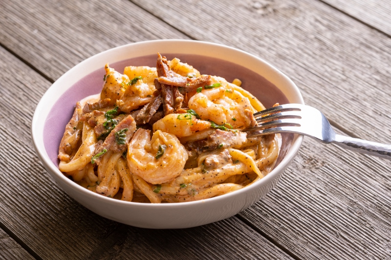 a bowl of crawfish or shrimp and tasso in cream on pasta