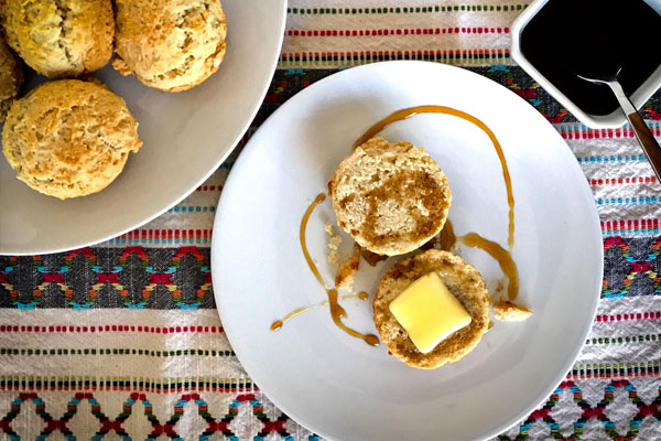 a plate of Southern Biscuit Muffin next to a plate full of them