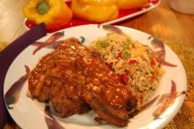 a plate full of calves liver with fire roasted pepper sauce