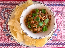 a plate with tortilla chips surrounding a bowl of lemon pepper pico de gallo made with salt free sugar free magic
