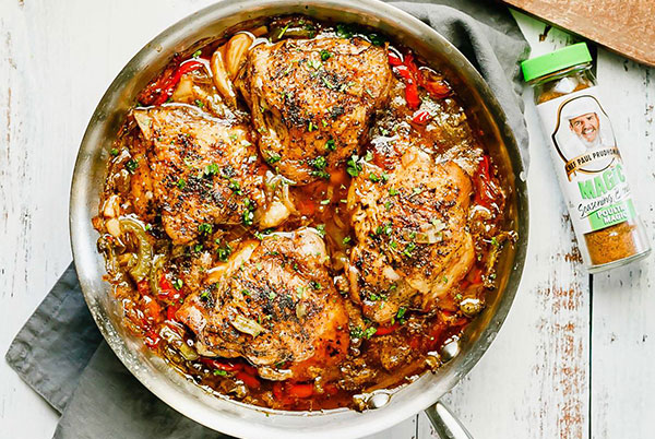 a cooking pot full of Braised Chicken Thighs next to a container of poultry magic