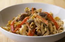 a close up of a bowl of jerk chicken pasta