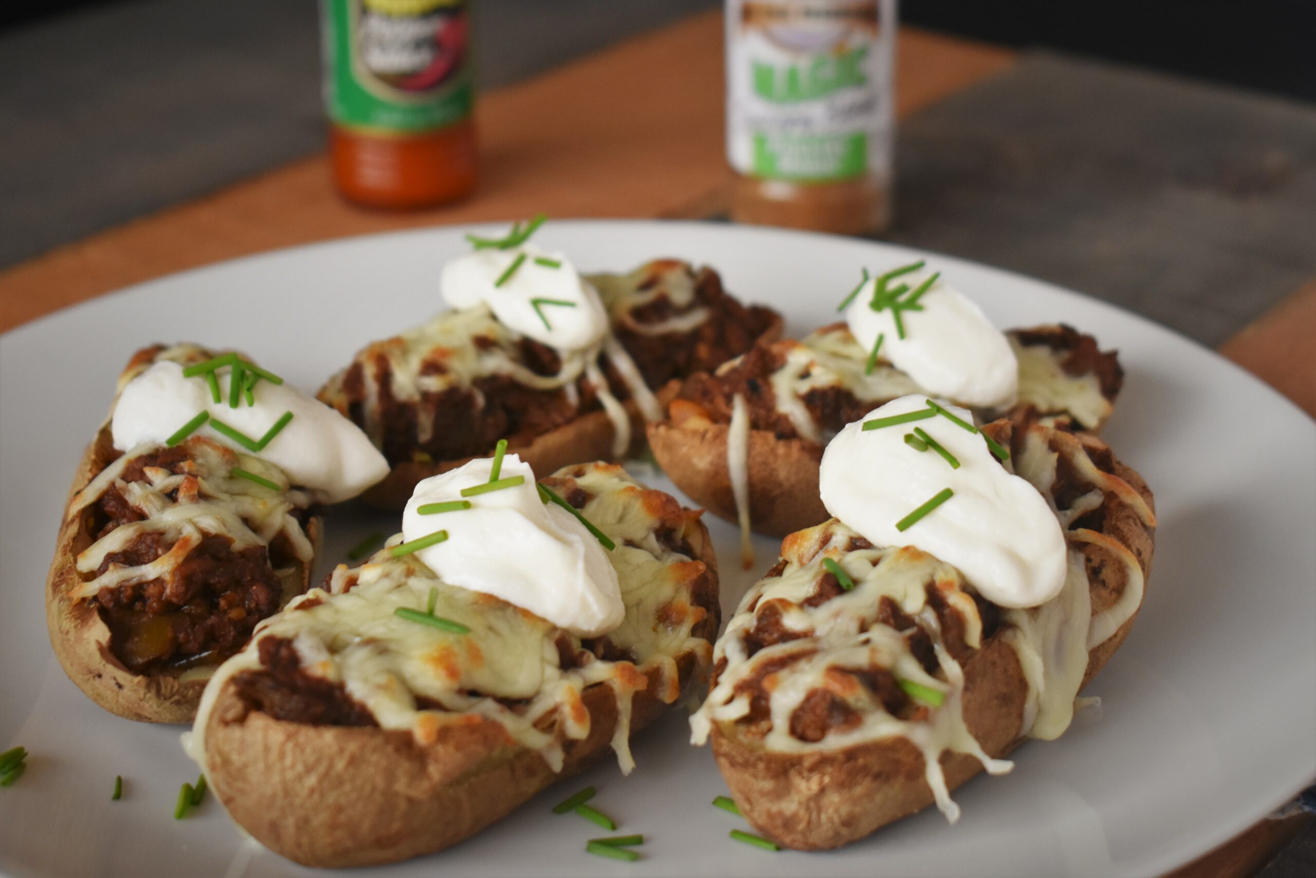 a plate of 5 potacos, taco stuffed potatoes, topped with a dollap of sour cream