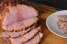 a magic glazed ham with slices cut out on it