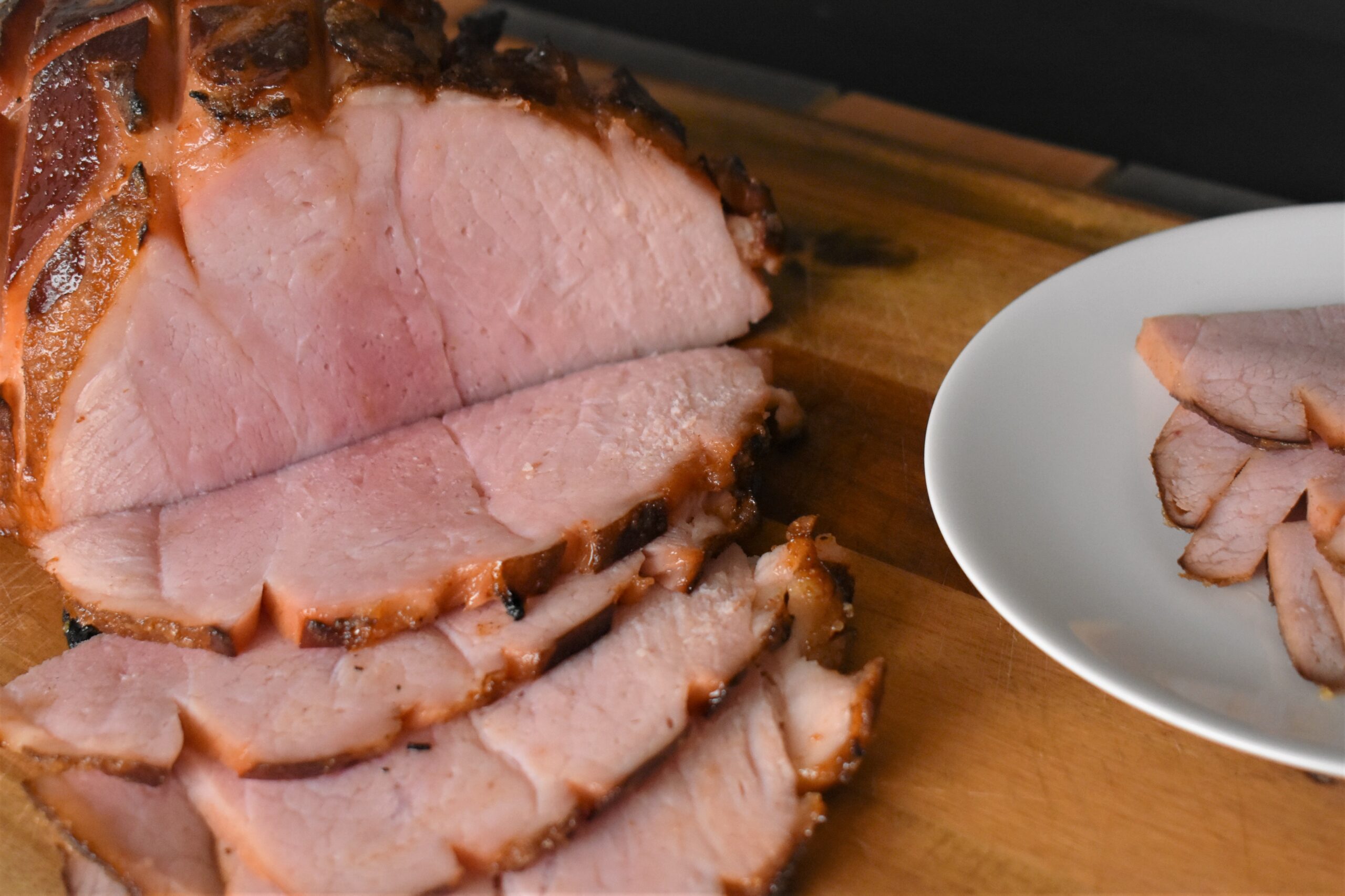 a magic glazed ham with slices cut out on it