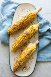 a plate with 3 grilled corn on the cobs