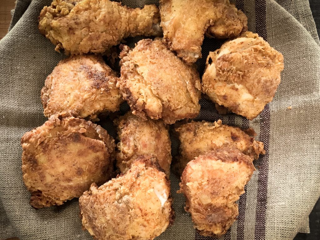 10 pieces of southern fried chicken on a plate thats been covered by a table cloth