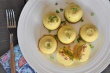 a plate of 7 andouille egg cups with chopped green onions on the plate