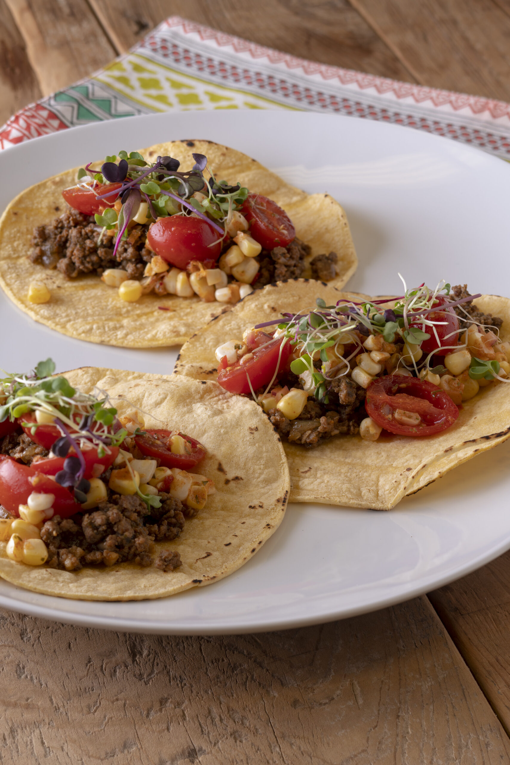 3 beef tacos with roasted corn and tomato salsa on a plate, cooked with salt free sugar free magic seasoning