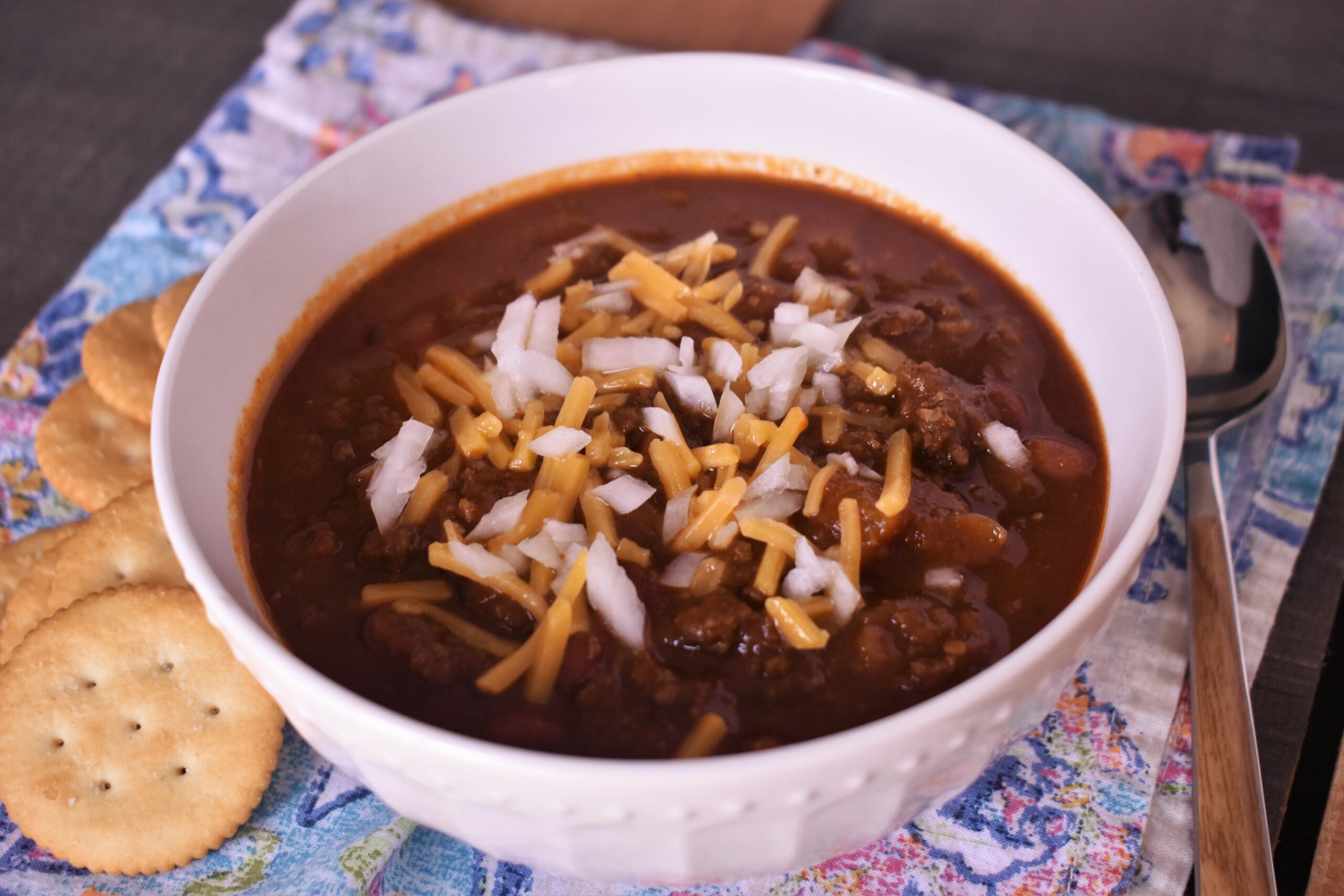 a bowl of instapot beef chilli with shredded cheese on top