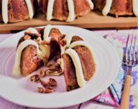 a carrot bundt cake with a frosting drizzle with a piece taken out of it