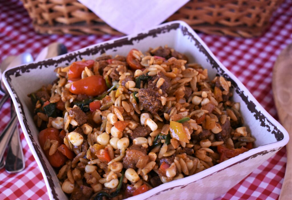 a sqaure bowl of orzo salad