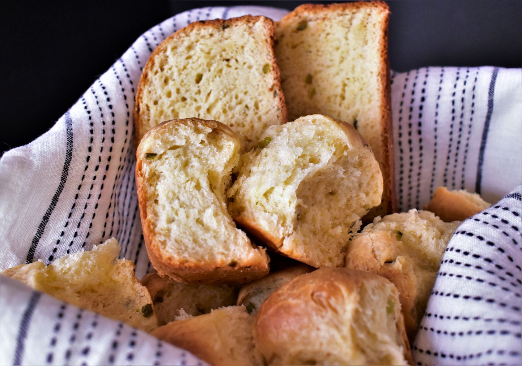 a basket of jalapeno cheddar cheese bread rolls