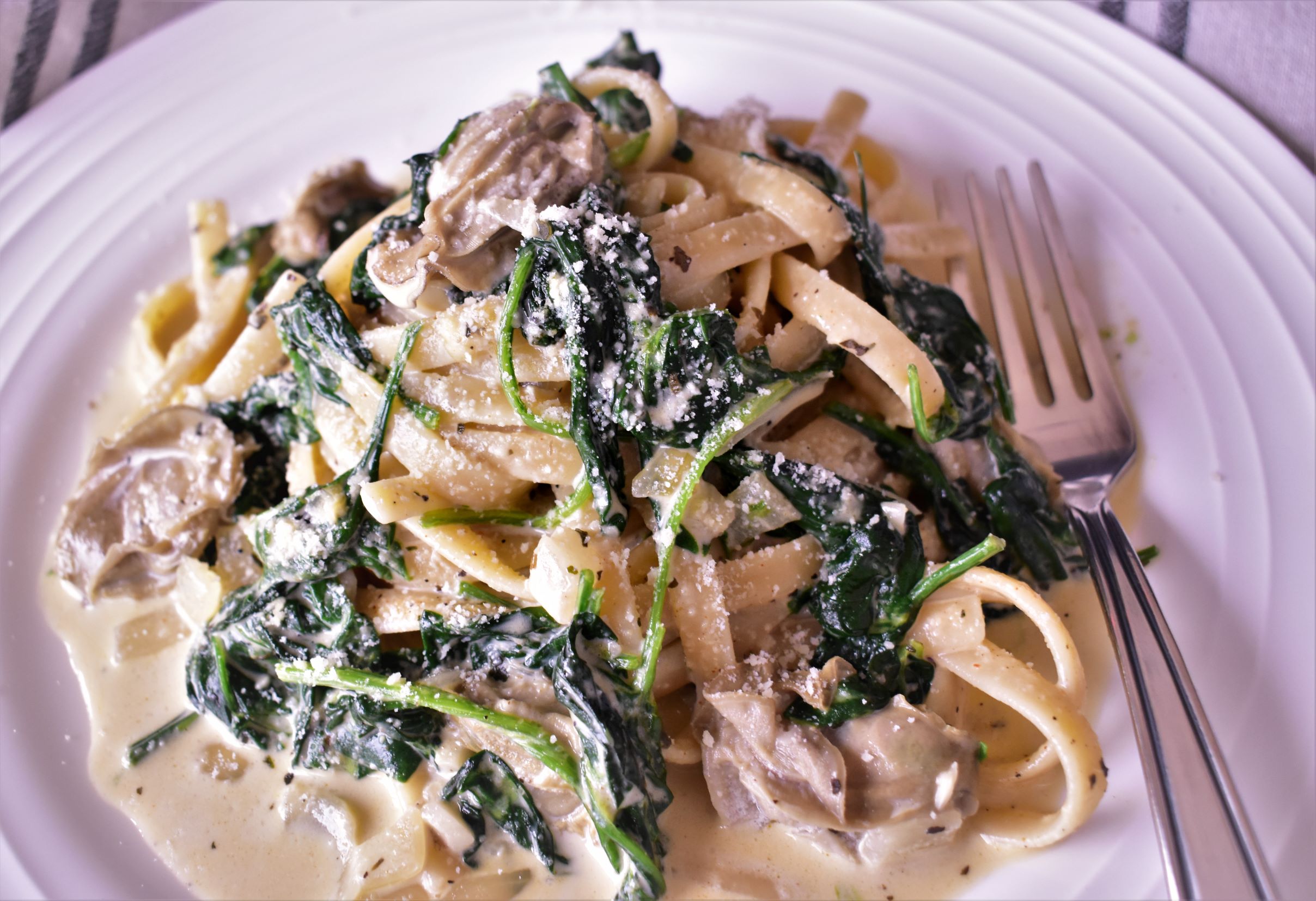 a plate of oysters florentine with spinach on top