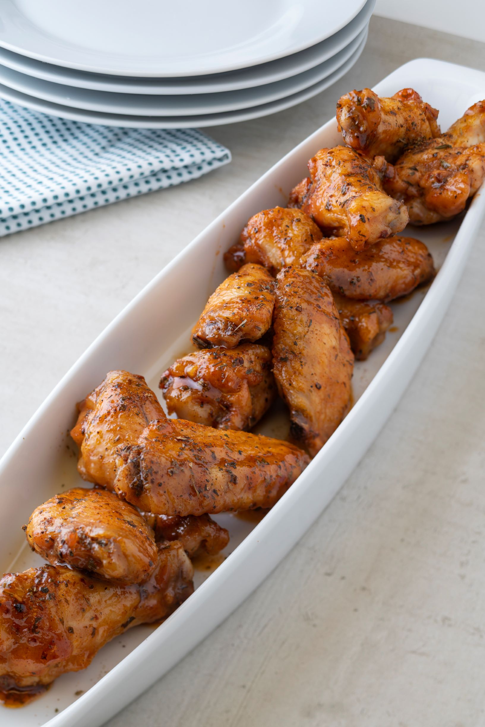 a serving dish of sweet basil and tarragon buffalo wings, including drumsticks and legs
