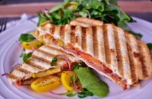 a plate of italian styled panini next to a side salad