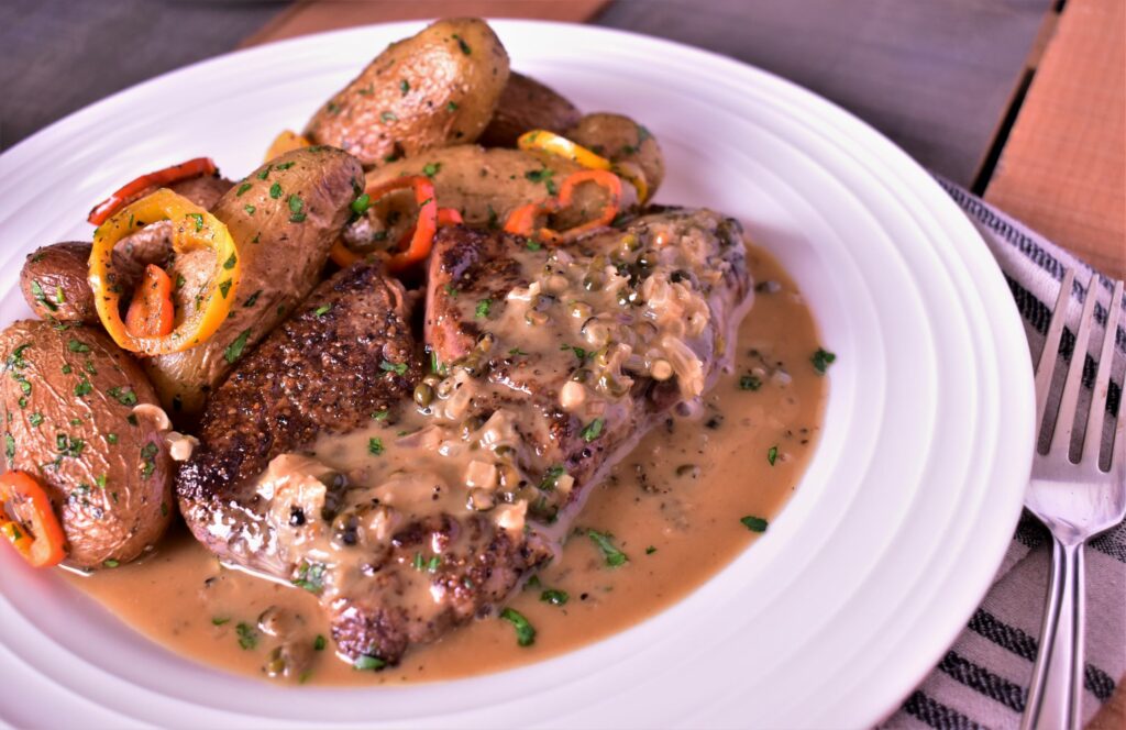 a plate of steak au poivre with gravy