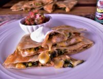 a plate of turkey and veggie quesadillas next to a cup of pico de gallio