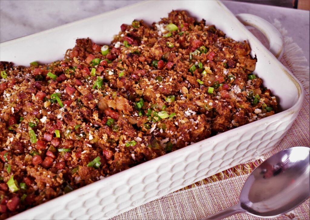 a serving dish of andouille and sasuage dressing with green onions on top