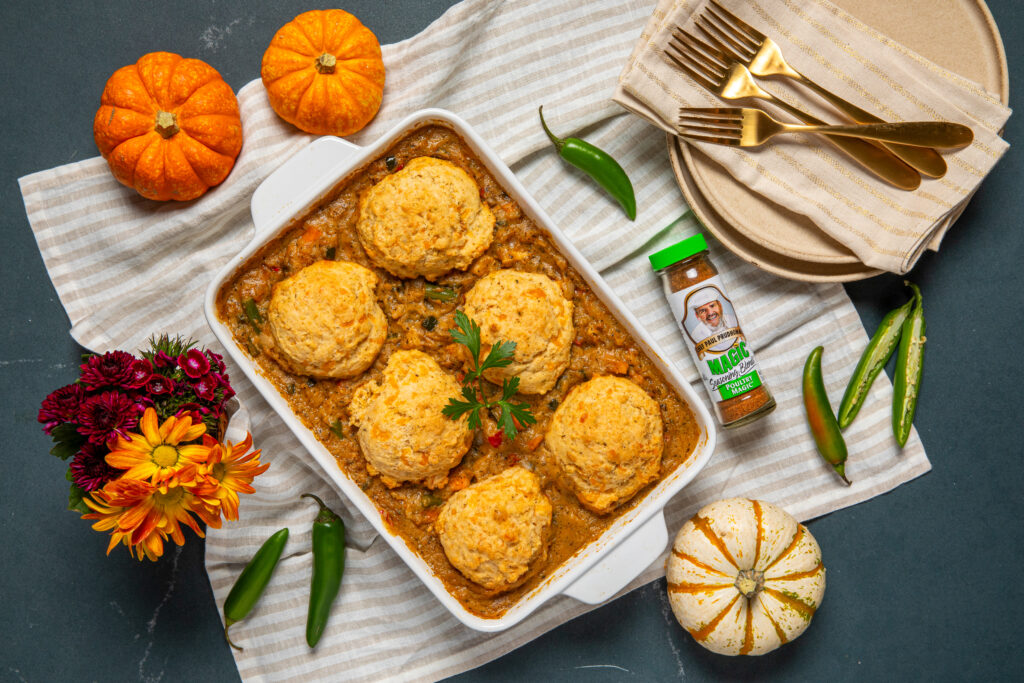 Pot Pie in a white serving dish with pumpkins and seasoning next to it