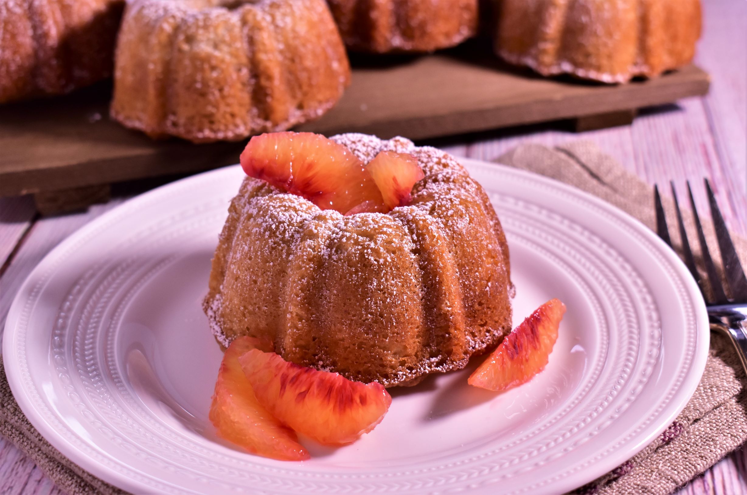 a personal sized almond and cream cheese pound cake with fruits on top