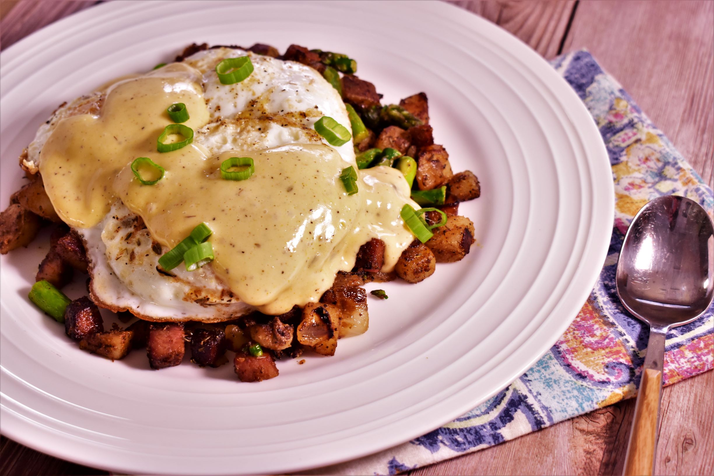 a plate of asparagus potato and tasso hash topped with green onions