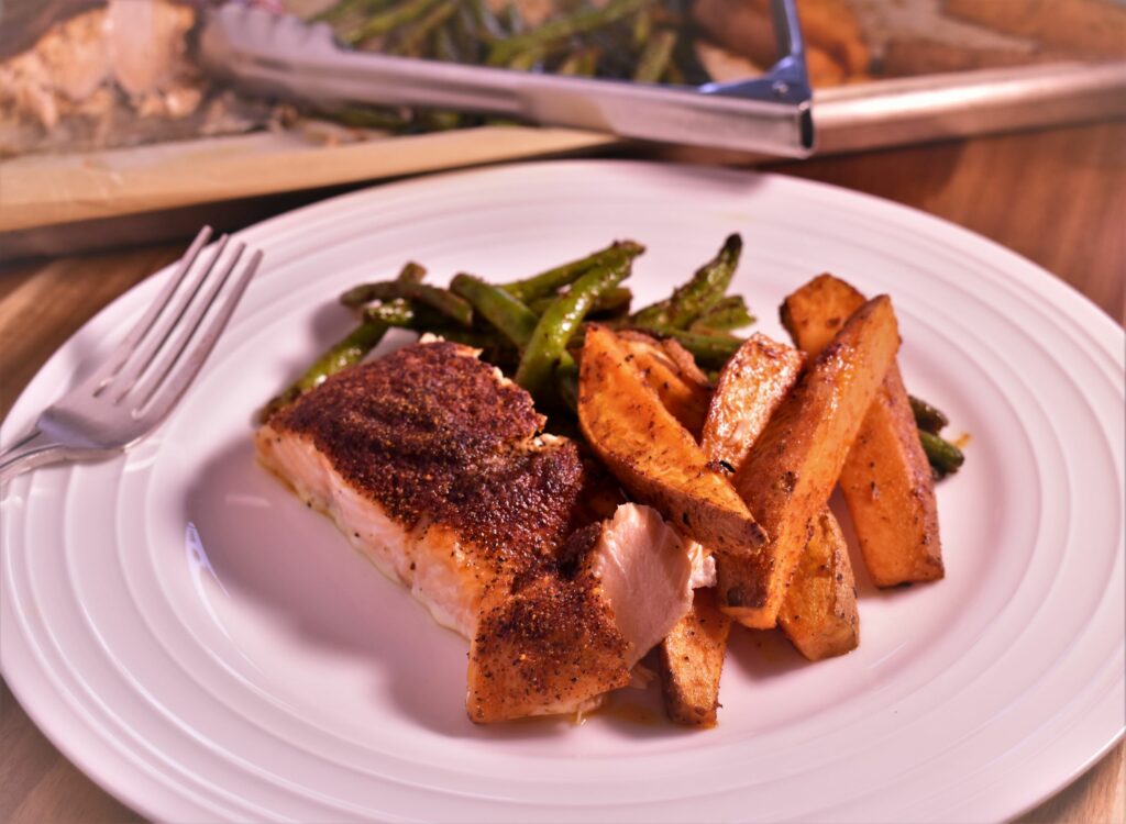 a plate of sheet pan salmon with a serving of green beans