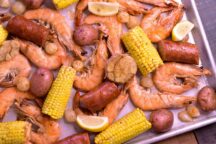 a sheet pan of boiled cajun shrimp with corn and potatoes