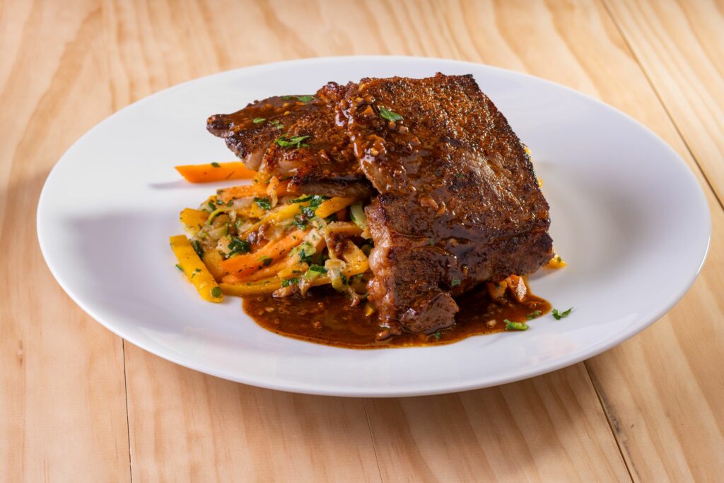 a plate of bbq magic ribeye steak with a side salad