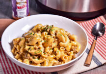 a bowl of instapot cheeseburger mac and cheese next to a container of burger magic and the insta pot it was cooked in