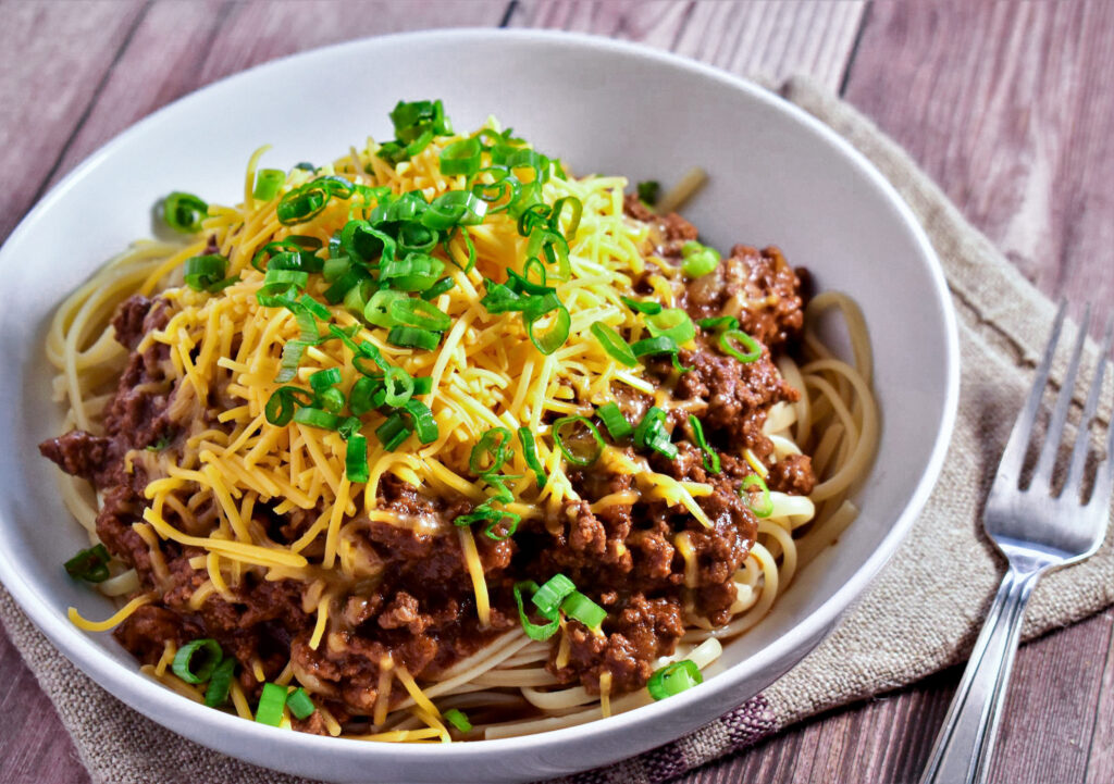 a bowl of cincinnati chili topped with green onions