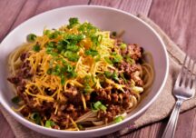 a bowl of cincinnati chili topped with green onions