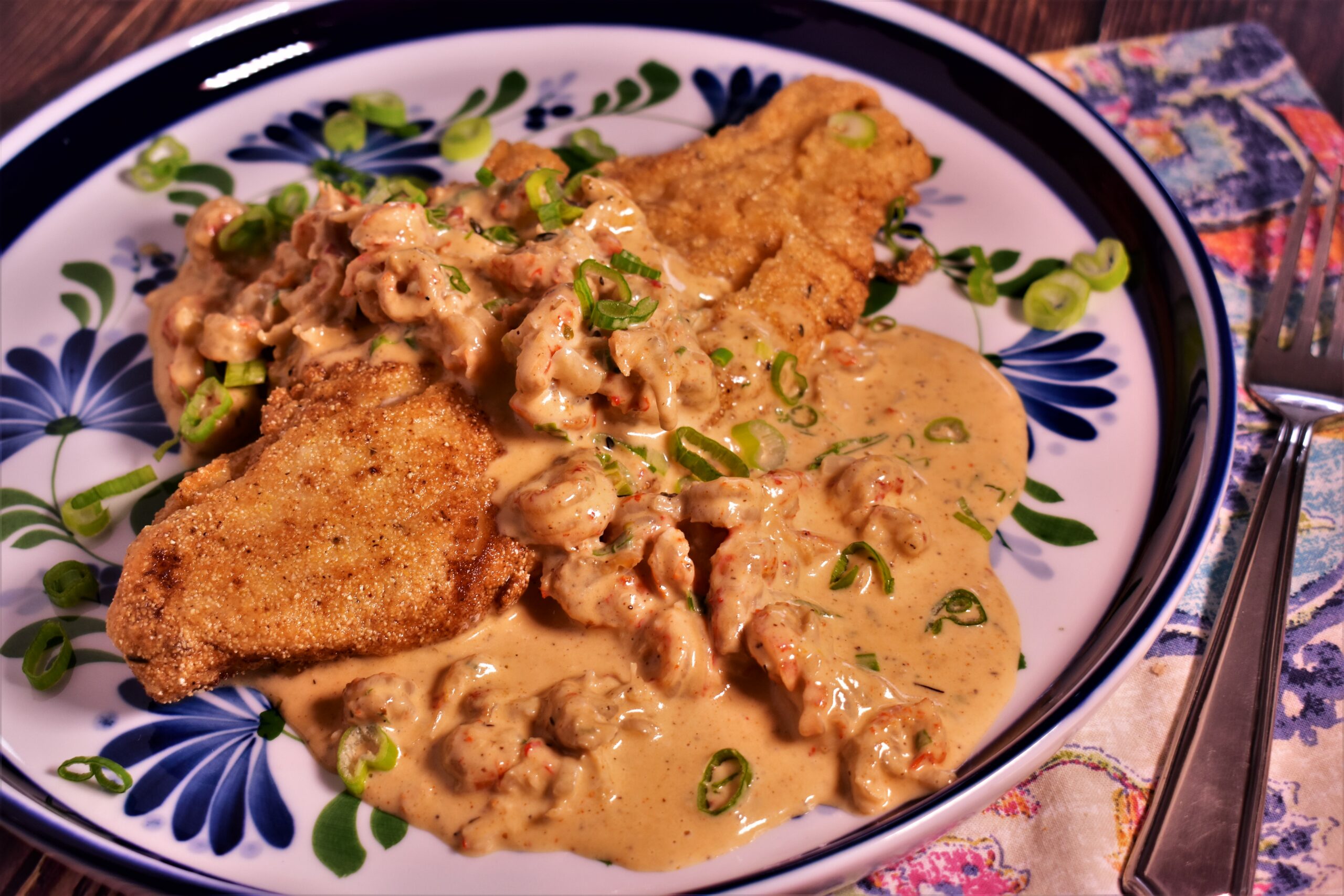 a plate of pan fried fish with creamy seafood sauce dribbled on it