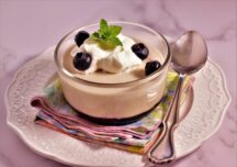 a cup of panna cotta with berry compote on a platter