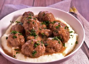 a bowl of swedish meatballs on top of mashed potatoes
