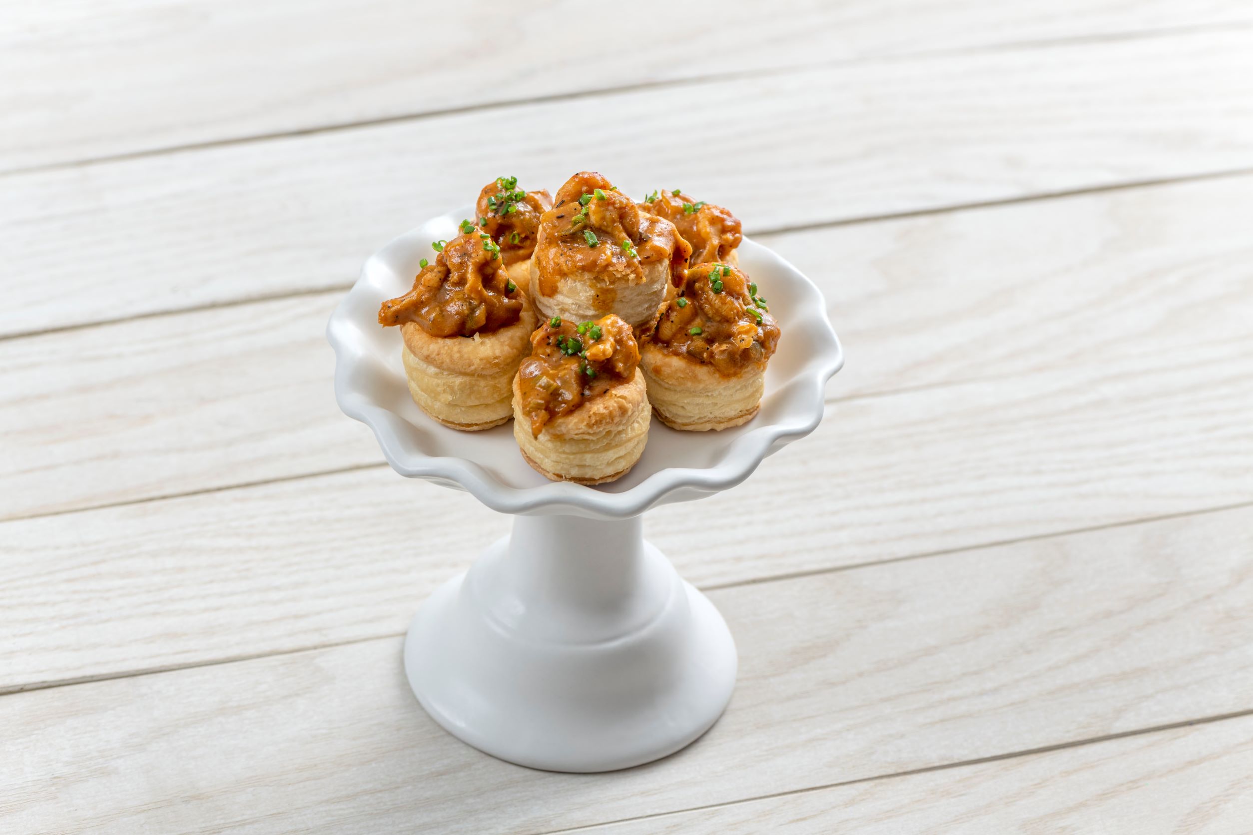 8 mini crawfish pies arranged in a tower on a fancy decorative platter
