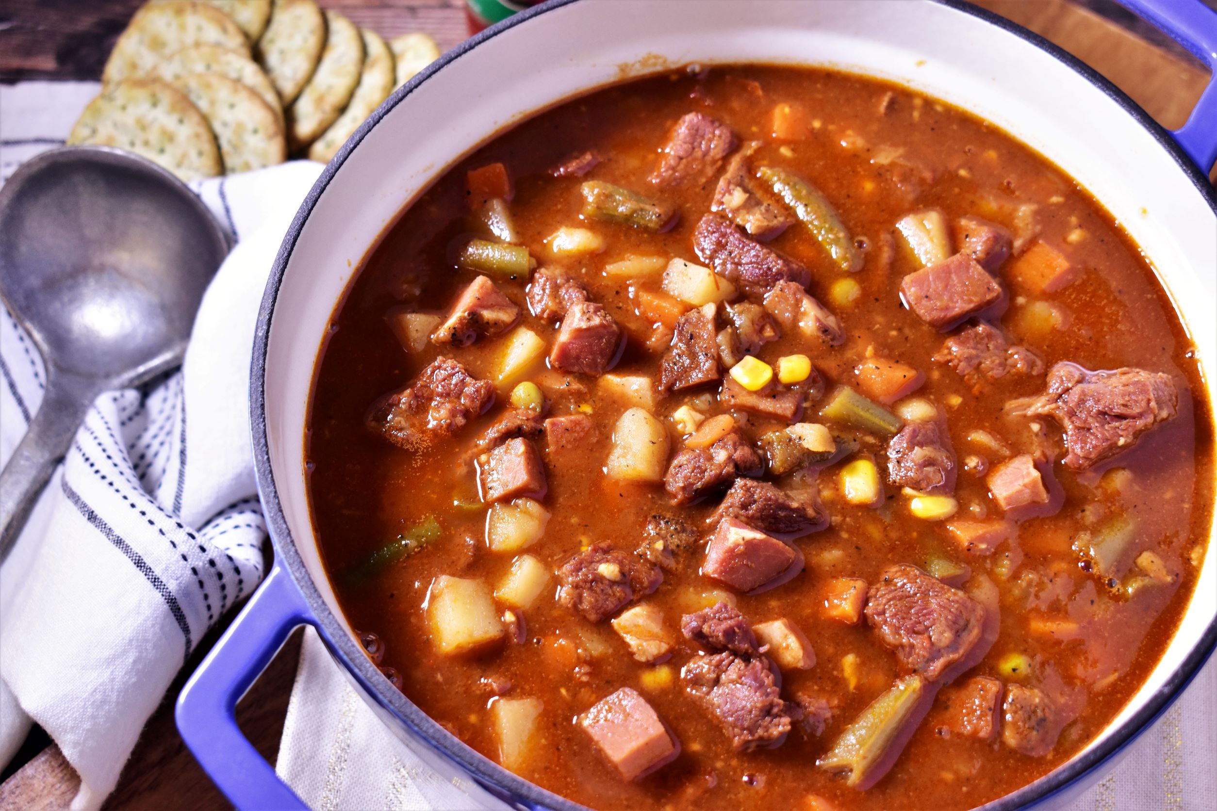 a dutch oven of vegtable beef soup with a side of crackers