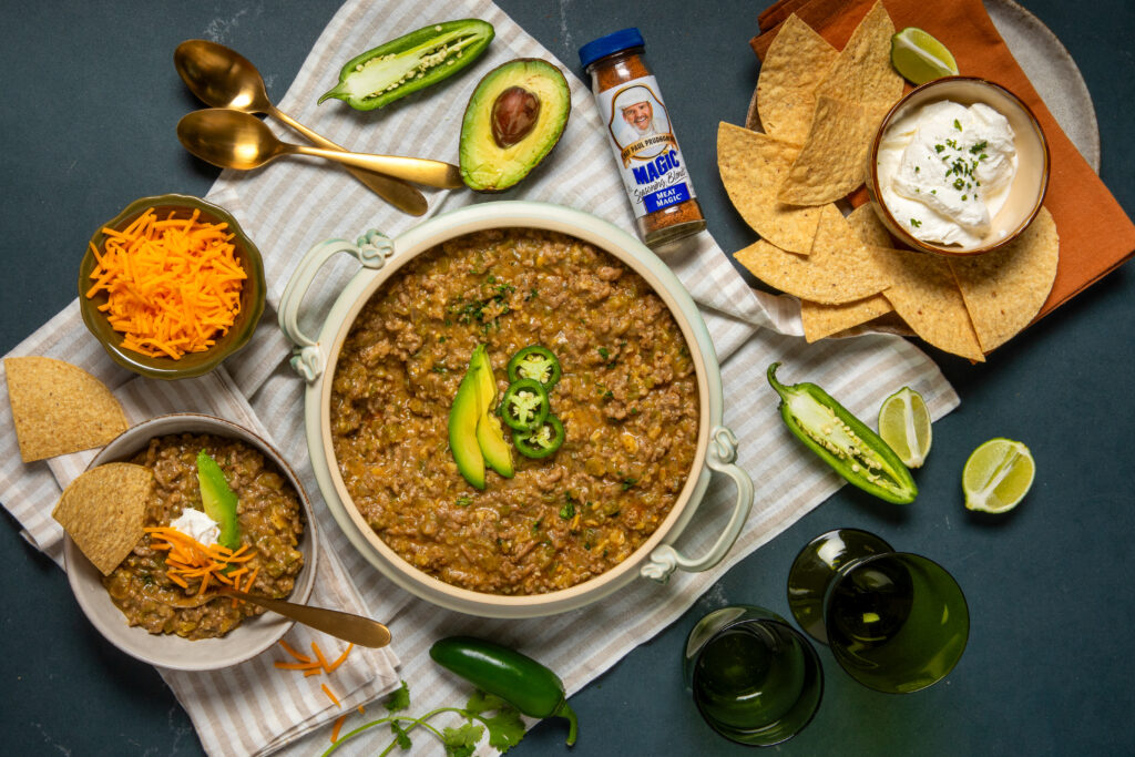 green chili in a serving dish with chips and ingredients next to it