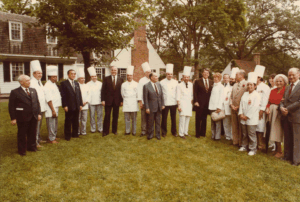 A group of international chefs and dignitaries, including U.S. President Ronald Reagan, pose for a photo on the lawn during the 1983 G7 Summit.